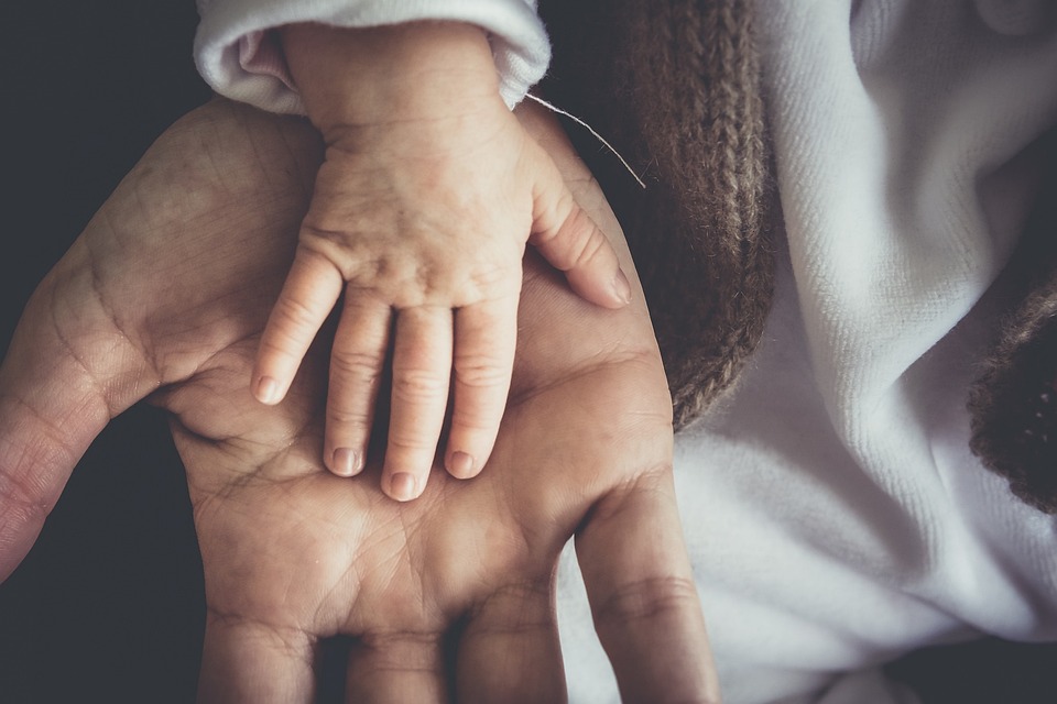 mano de bebé sobre mano de adulto